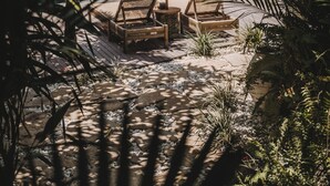 A poolside area with lounge chairs and a canopy. - Umakayu Joglo Villa Bali Boutique Hotel (Canggu)