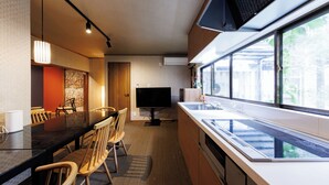 A modern kitchen with a dining area, large windows, and a flat-screen TV. - R-Guest Residence Tsurumibashi (Osaka)