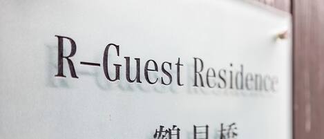 Une enseigne indiquant « R-Guest Residence » et comportant des caractères chinois.