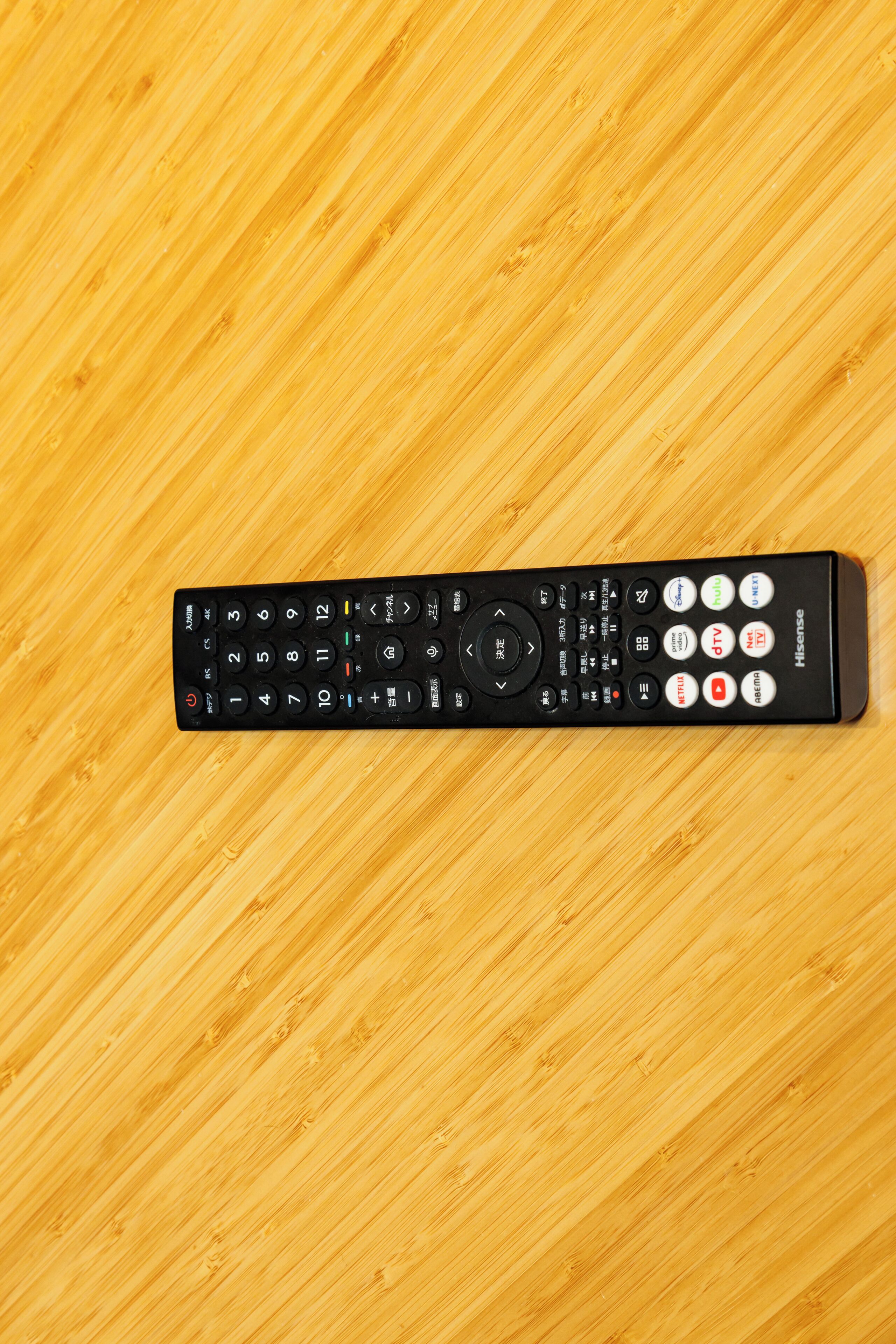 A remote control on a wooden surface.