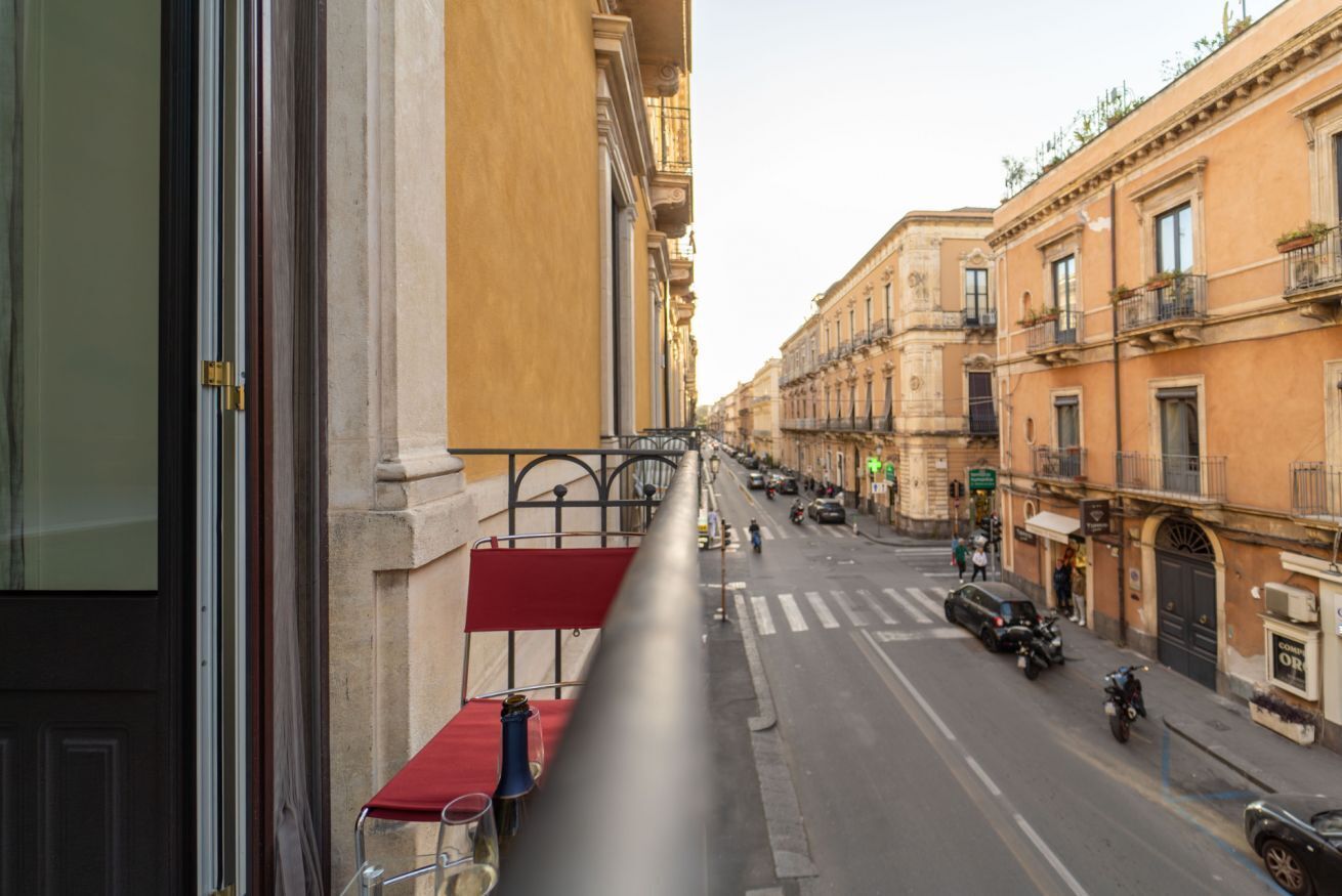 Una vista de carrer amb edificis als costats, una tenda amb estora vermella i motocicletes aparcades.