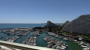 Un port de plaisance où sont amarrés de nombreux bateaux, entouré d’immeubles modernes de grande hauteur.