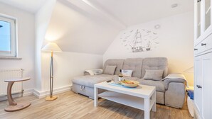 Una sala de estar moderna con un sofá, una mesa de centro, una lámpara y un mural en la pared.
