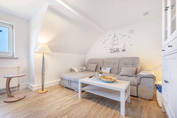 A modern living room with a sofa, a coffee table, a lamp, and a wall mural.