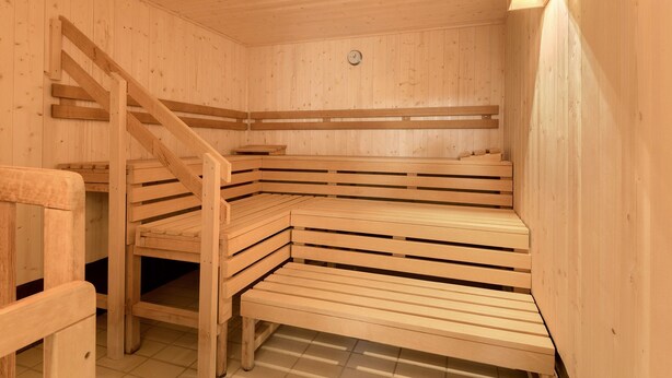 Una sauna amb seients de fusta i una escala de fusta.