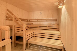 Sauna, jossa on puiset lauteet ja puinen portaikko.