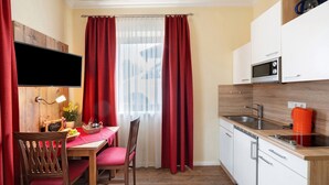 A compact kitchen with a microwave, sink, and wooden cabinets. - Apartment 'Komfort  Römersberger - 1' with Wi-Fi (Vogtareuth)