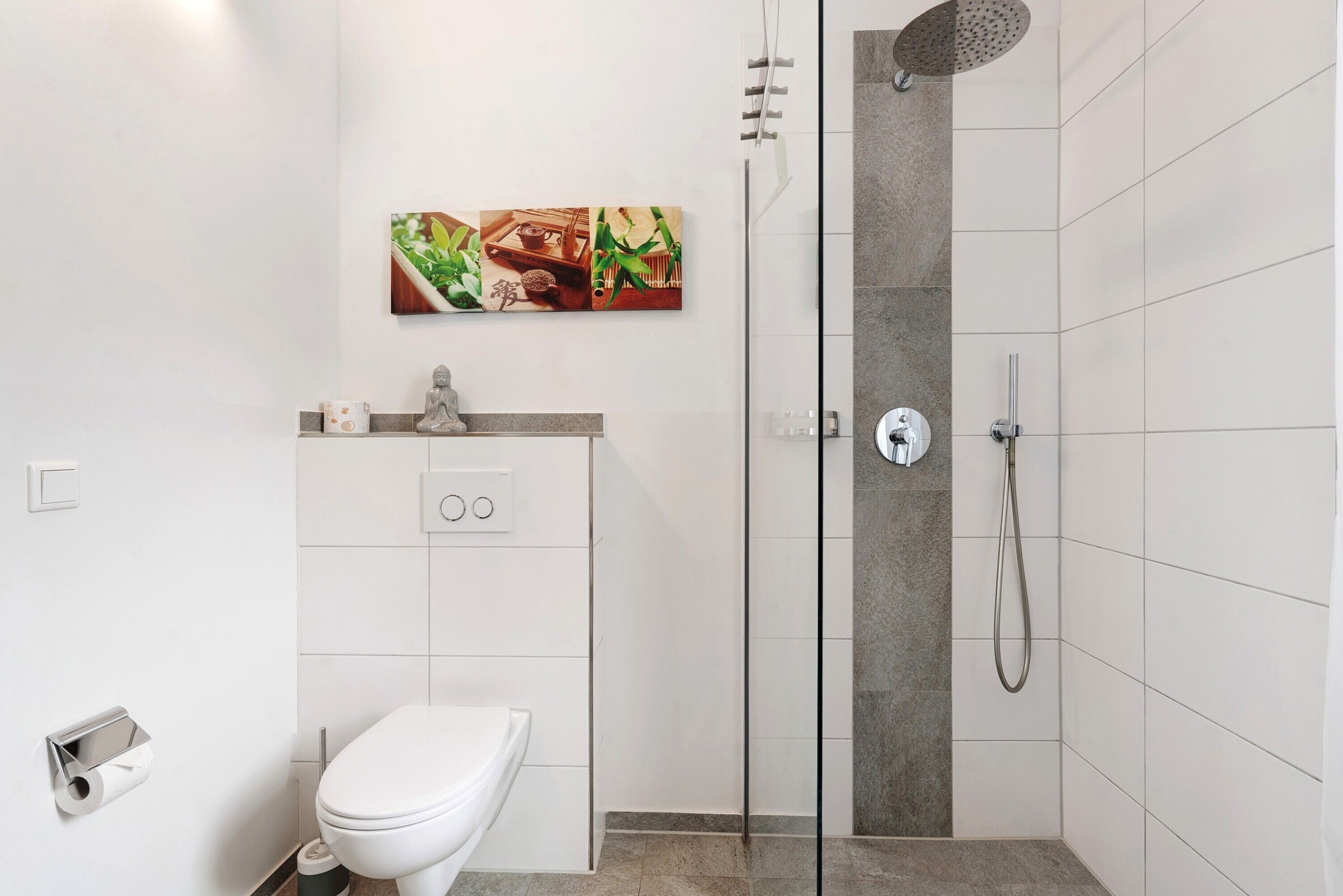 A modern bathroom with a glass-enclosed shower, a toilet, and a sink with a countertop.