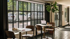 A hotel room with a large window, a laptop on a table, and a potted plant. - The Industrialist Belvilla District 6 Formerly Sonder (Brooklyn)