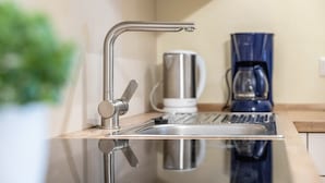 A modern kitchen with a stainless steel sink, a coffee maker, and a kettle. - Holiday Apartment 'Komfort Römersberger - 6' with Private Terrace, Private Garden and Wi-Fi (Vogtareuth)