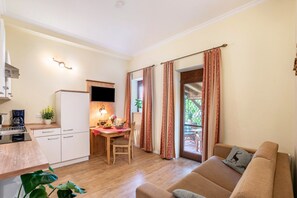 Un espacio habitable compacto con kitchenette, comedor y sofá.