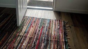 A room with a large window, a colorful striped rug, and a dog lying outside. - Updated 1BR w/ Kitchen, Fast WiFi + Highway Access Near Carrizo Plain (Cuyama)