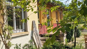 Un edificio de dos pisos con un balcón, una puerta de madera y una ventana con reja de metal.
