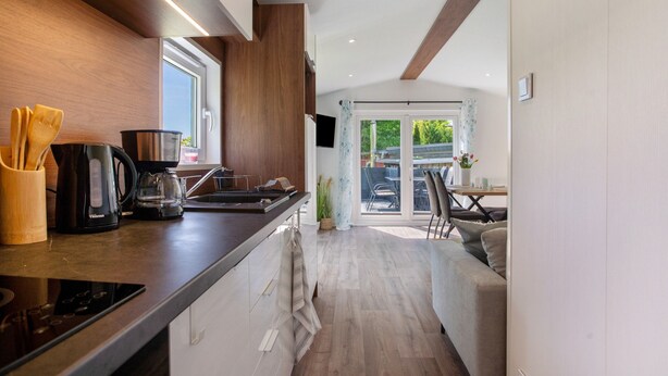 Una cocina moderna con encimera de madera, cafetera y hervidor.