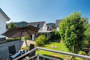A patio with outdoor furniture, a table, and an umbrella. - Apartment 'Zum Alten Wald' with Private Terrace and Wi-Fi (Zell am Harmersbach)