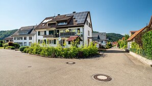 A residential building with solar panels, a balcony, and a clear sky.