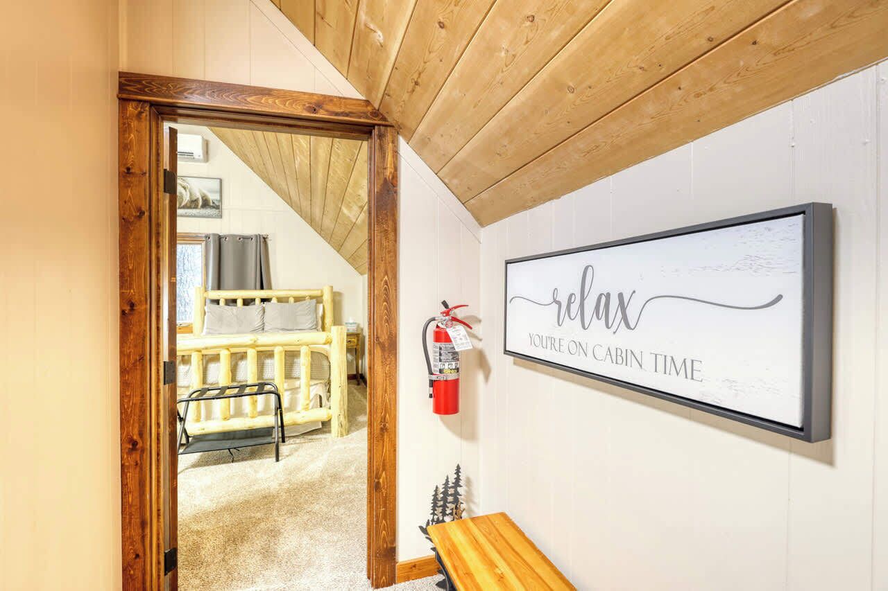 L'intérieur d'une cabine avec un plafond en bois, une pancarte encadrée indiquant « détendez-vous, vous êtes en mode cabine », un extincteur et un banc.