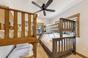 A bunk bed room with a ceiling fan, wooden railings, and a carpeted floor. - The Pine & Trail Tahoe | 4BR | Hot Tub + 3 Kings (South Lake Tahoe)