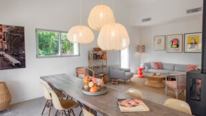 A modern living room with a wooden dining table, chairs, a bookshelf, and a sofa. - Luxury villa with A/C and a heated private pool (La Croix-Valmer)