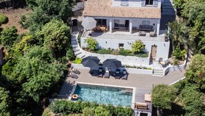 A large house with a swimming pool, outdoor seating, and lush greenery. - Luxury villa with A/C and a heated private pool (La Croix-Valmer)