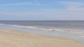 Enjoy a serene beach experience with gentle waves lapping at the shore.