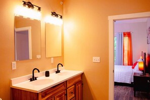 Un baño con dos lavamanos, un espejo y un mueble de tocador con cajones.