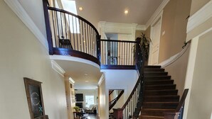Un hall d’entrée spacieux avec un escalier en colimaçon menant au deuxième étage.