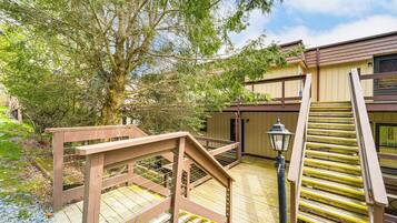 A wooden deck with a wooden staircase leading to a building.