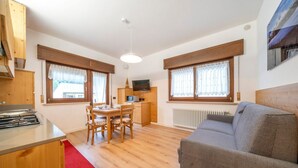 Een compacte woonruimte met een kitchenette, een eethoek en een zithoek.