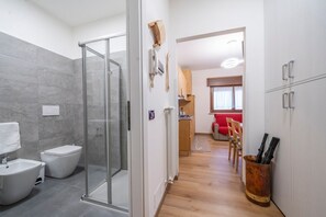 Une salle de bain moderne avec une douche à parois de verre, un bidet et des toilettes.