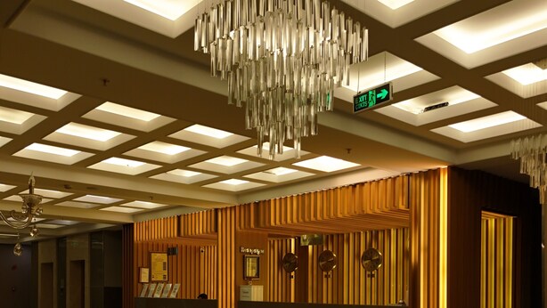 A hotel lobby with a reception desk, a chandelier, and a patterned floor. - Rabat Resort Hotel (Adiyaman)