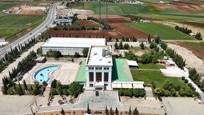 A large building with a swimming pool, parking lot, and surrounding greenery. - Rabat Resort Hotel (Adiyaman)
