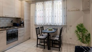 Une cuisine équipée d’une table à manger, de chaises, d’une cuisinière et d’un four.