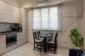A kitchen with a dining table, chairs, a stove, and an oven.