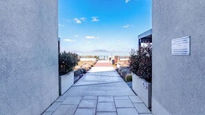 A pathway leading to a building with a clear view of a mountainous landscape. - Sunset Resort 409 With Pool (Fonyod)