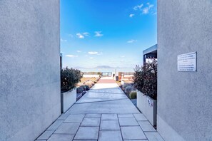 A pathway leading to a building with a clear view of a mountainous landscape. - Sunset Resort 409 With Pool (Fonyod)