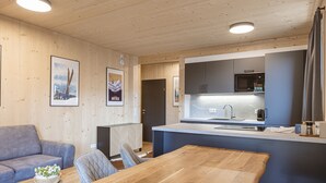 Una cocina moderna con microondas integrado, un fregadero y una mesa de comedor de madera.