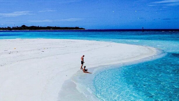Ein Strand mit klarem türkisblauem Wasser und weißem Sand.