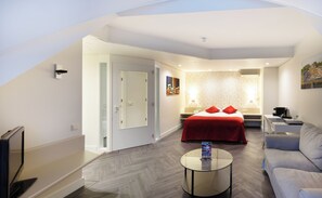 Relax in a stylish space with a comfortable bed, sofa, and seating area.