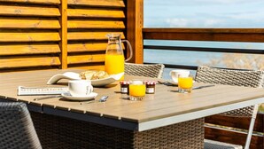 A breakfast table with a pitcher of orange juice, a newspaper, and a plate of toast.