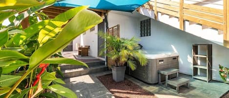 Eine Terrasse mit Whirlpool, Blumentöpfen und einer Holzterrasse.