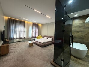 A modern bedroom with a large bed, a glass shower enclosure, and a minimalist design. - Casa Blu (Tbilisi)