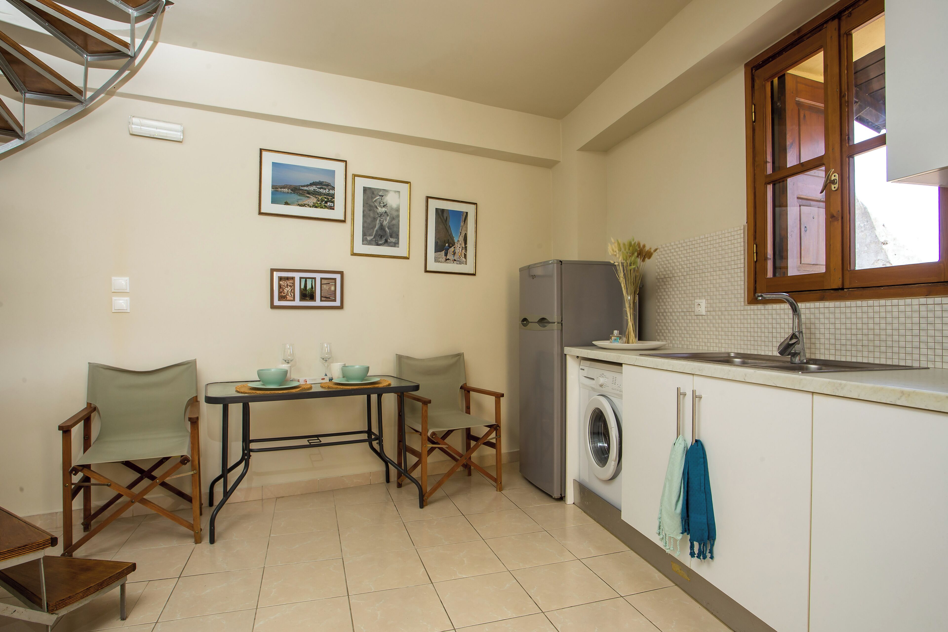 Una cocina compacta con comedor, lavadora y ventana con vistas.
