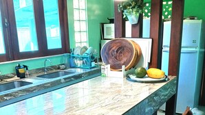 A kitchen with a large marble countertop, two sinks, wooden chairs, and a refrigerator. - AMAZON HOME AND JUNGLE TRIPS (Manaus)