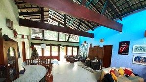 A spacious living area with a high ceiling, a dining table, and a sofa. - AMAZON HOME AND JUNGLE TRIPS (Manaus)
