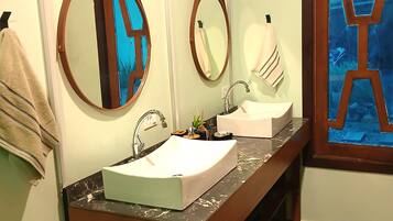 A bathroom with a wooden vanity, two sinks, and two wall-mounted mirrors.