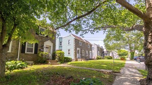A row of townhouses with a well-maintained lawn and a sidewalk. - Family Home-Sleeps 8-Spacious 3BR-Free Parking-8 Min to PHL (Sharon Hill)