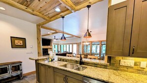 A kitchen with granite countertops, stainless steel appliances, wooden cabinets, and pendant lighting. - Chateaux Dumont 2724 (Keystone)