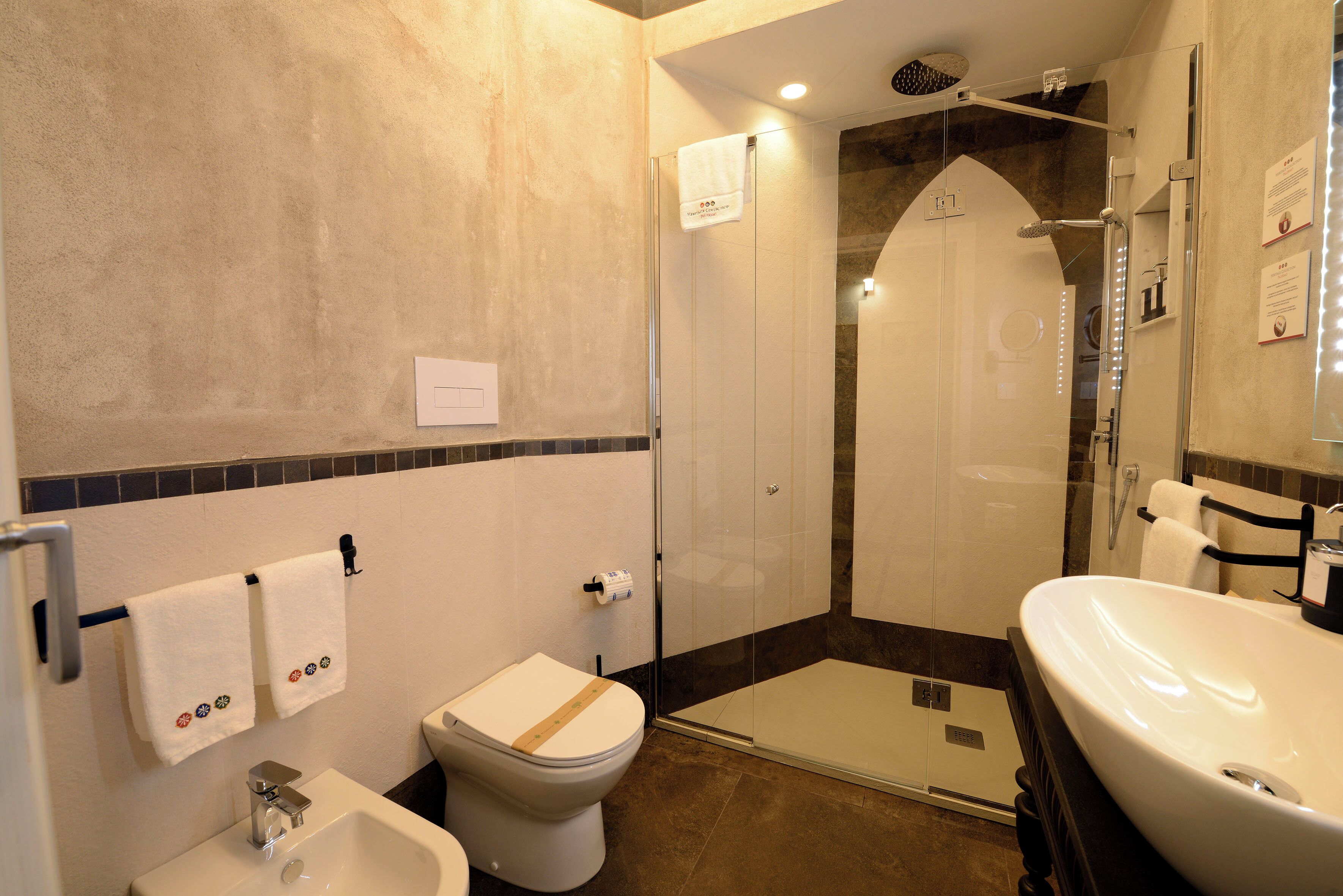 Une salle de bain équipée d’une douche, de toilettes, d’un bidet et d’un lavabo.