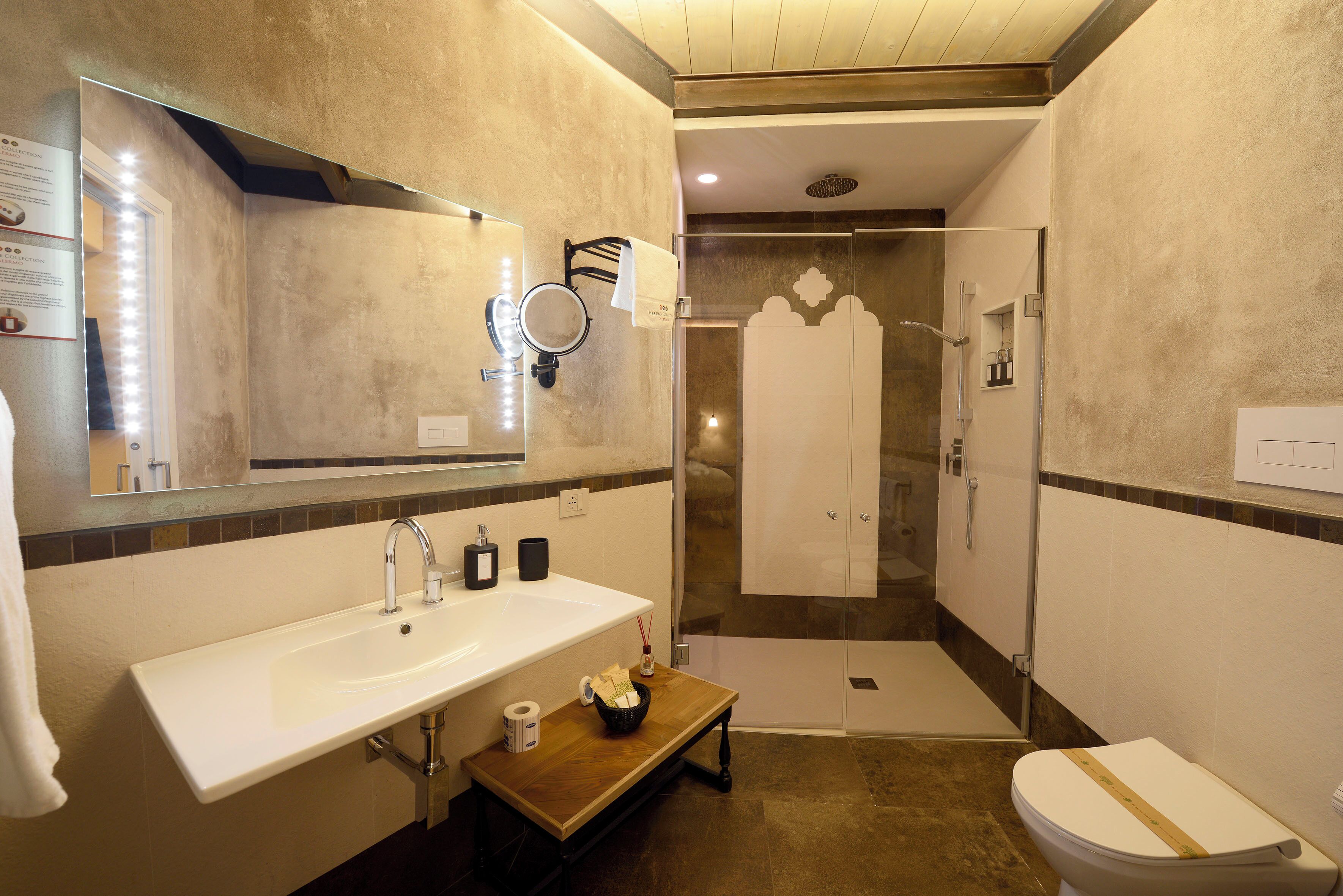 A modern bathroom with a large sink, mirror, and shower.